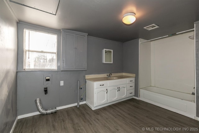 clothes washing area featuring washer hookup, cabinets, dark hardwood / wood-style flooring, and sink