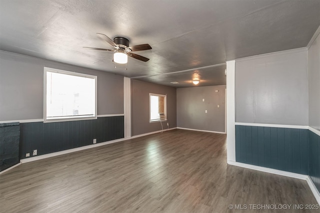 unfurnished room featuring ceiling fan, dark hardwood / wood-style flooring, and a healthy amount of sunlight