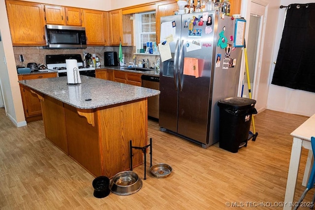 1799 W Main St, Westville, OK 74965 - kitchen with stainless steel appliances, light wood-style flooring, a sink, brown cabinetry, and backsplash
