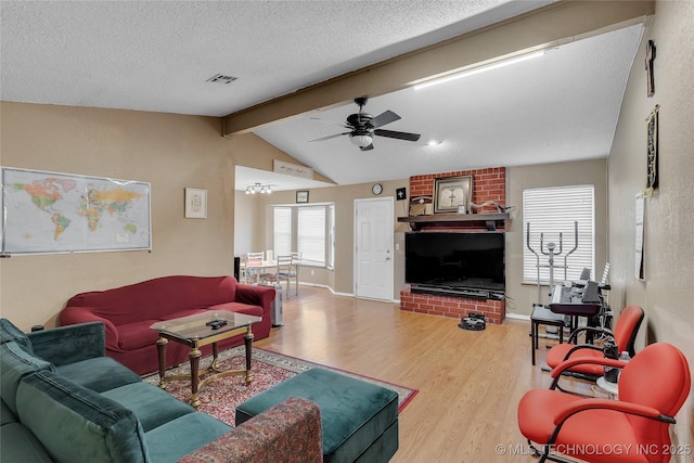 living room featuring a textured ceiling, ceiling fan, hardwood / wood-style floors, and lofted ceiling with beams