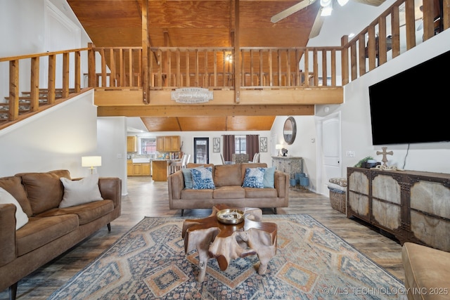 living room featuring hardwood / wood-style flooring, wood ceiling, ceiling fan, and vaulted ceiling with beams