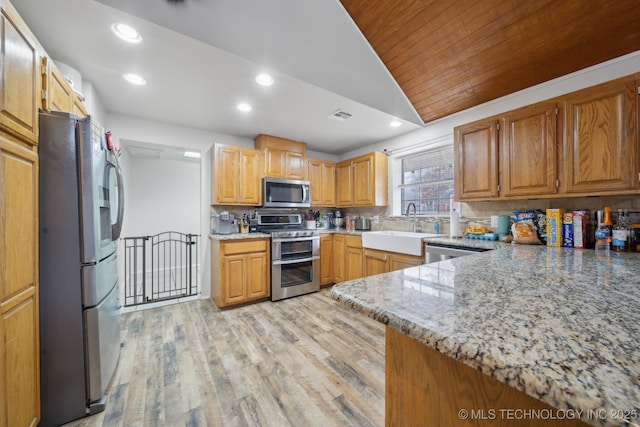 kitchen with stainless steel appliances, wood ceiling, backsplash, and light stone countertops