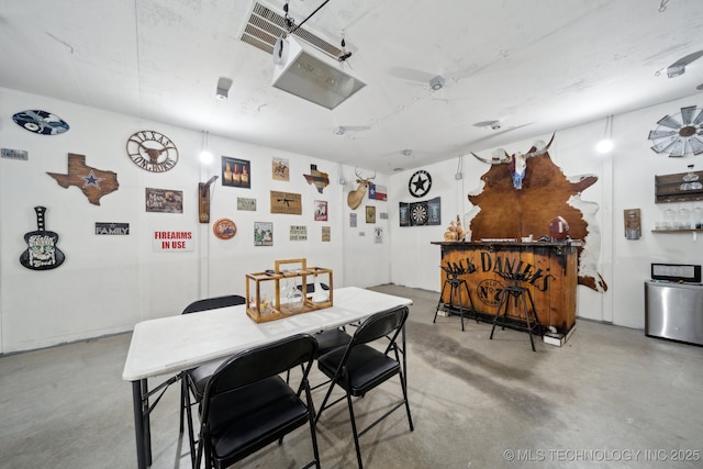 dining room featuring ceiling fan and concrete flooring