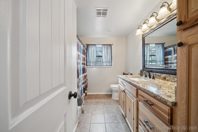 bathroom featuring toilet, tile patterned flooring, plenty of natural light, and vanity