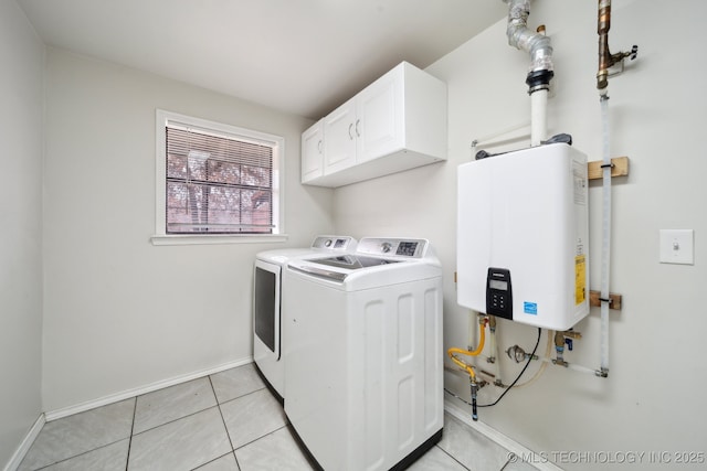 laundry area featuring water heater, light tile patterned flooring, washing machine and clothes dryer, and cabinets