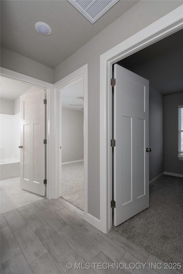 hallway featuring light colored carpet