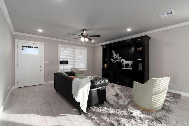 living room with ceiling fan, ornamental molding, and light hardwood / wood-style flooring