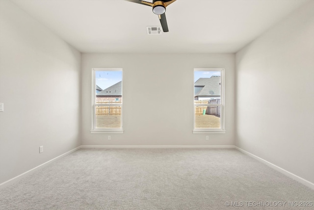 spare room featuring carpet floors, baseboards, and visible vents