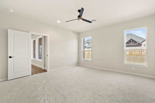 carpeted empty room featuring a ceiling fan, recessed lighting, visible vents, and baseboards