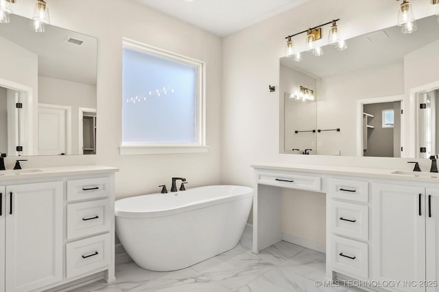 bathroom featuring marble finish floor, two vanities, a sink, and visible vents