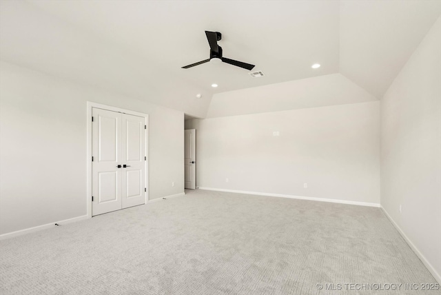 spare room featuring baseboards, vaulted ceiling, a ceiling fan, and light colored carpet