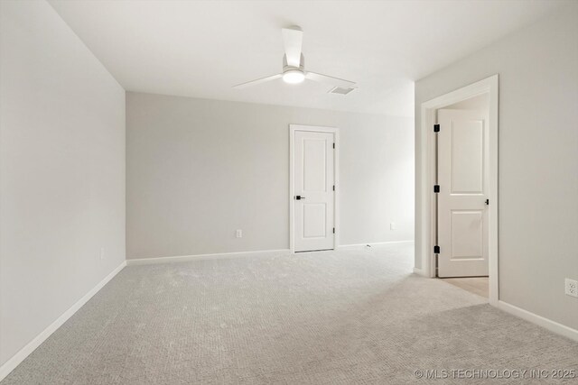 spare room featuring baseboards, a ceiling fan, and light colored carpet