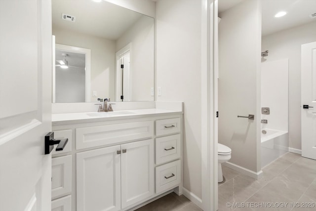 bathroom with toilet, vanity, visible vents, and baseboards