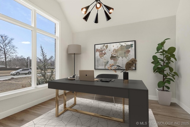 office area featuring lofted ceiling, light wood-style floors, and baseboards