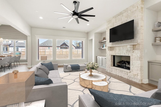 living area with built in features, a fireplace, recessed lighting, wood finished floors, and baseboards