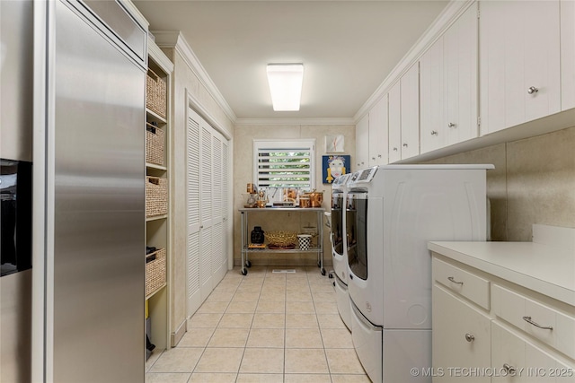 clothes washing area featuring light tile patterned floors, independent washer and dryer, ornamental molding, and cabinets