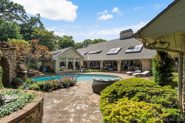 view of pool featuring an outbuilding and a patio