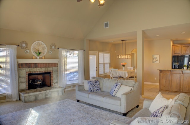 carpeted living room featuring ceiling fan, high vaulted ceiling, and a fireplace