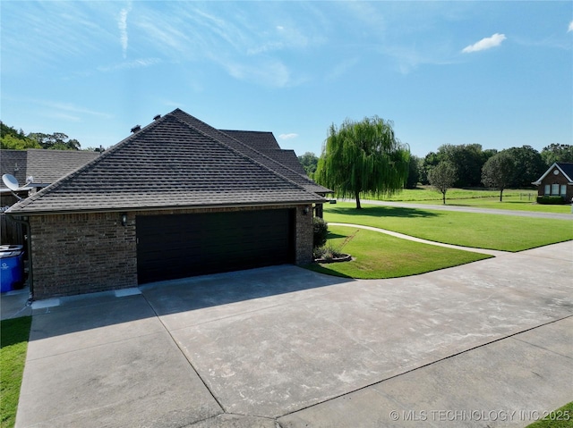 view of side of property featuring a garage and a lawn