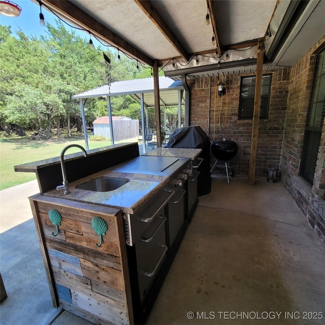 view of patio with area for grilling, an outdoor kitchen, and sink