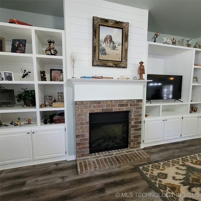 living room featuring a brick fireplace and dark hardwood / wood-style floors