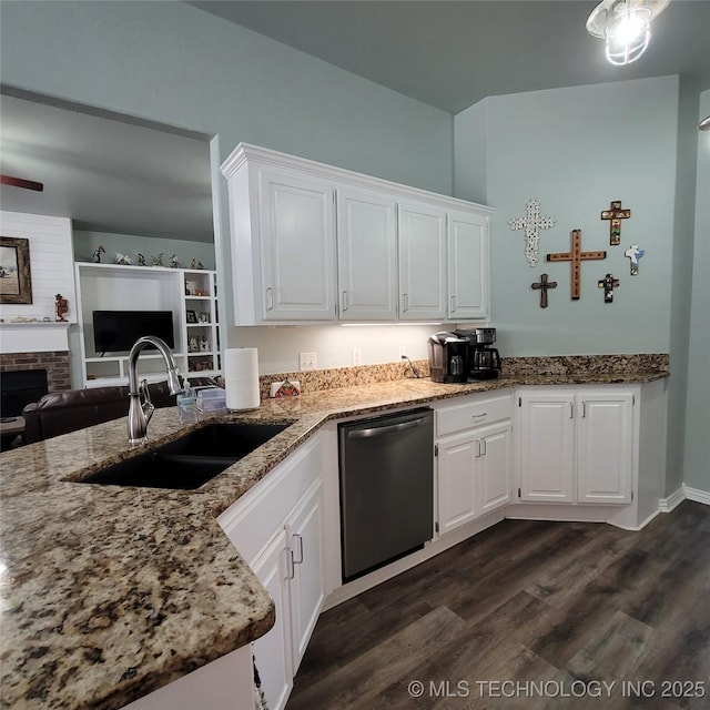 kitchen with white cabinets, dishwasher, dark wood-type flooring, a fireplace, and sink