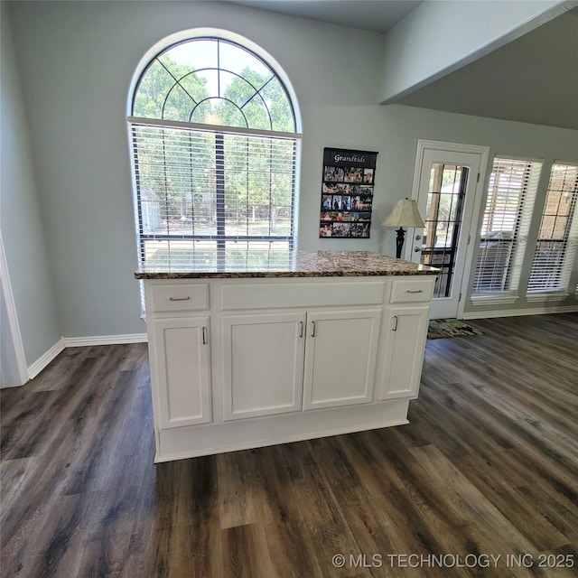 kitchen with stone counters, white cabinetry, a healthy amount of sunlight, and dark hardwood / wood-style flooring