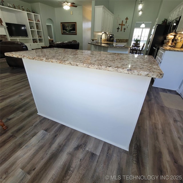 kitchen with ceiling fan, dark hardwood / wood-style flooring, white cabinets, and light stone counters