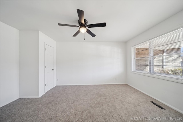 carpeted spare room featuring ceiling fan