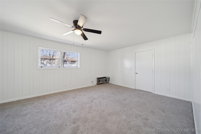 carpeted empty room with ceiling fan and heating unit