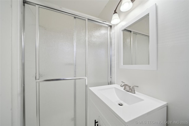 bathroom with vanity and a shower with door