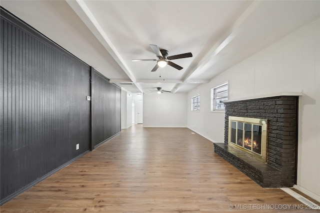 unfurnished living room featuring ceiling fan, a fireplace, light hardwood / wood-style floors, beam ceiling, and coffered ceiling