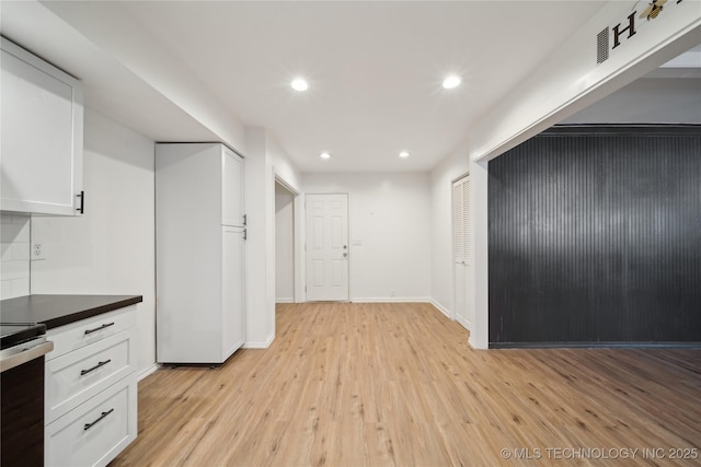 kitchen with electric stove, white cabinets, and light hardwood / wood-style floors