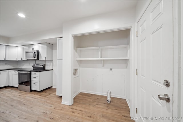 kitchen featuring light hardwood / wood-style flooring, stainless steel appliances, backsplash, and white cabinets