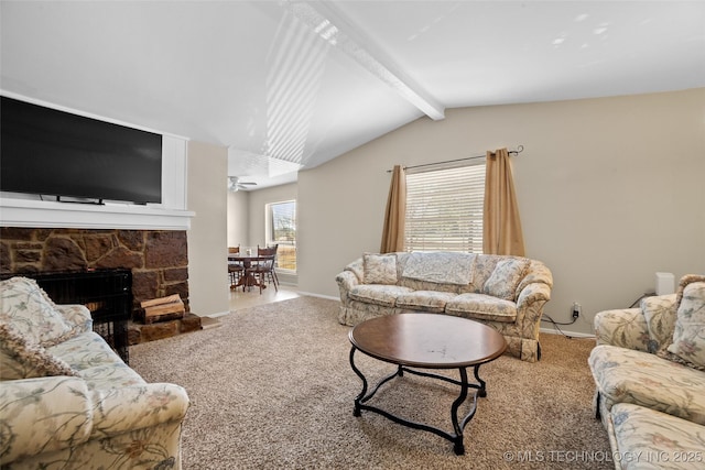 living room with ceiling fan, lofted ceiling with beams, a stone fireplace, and carpet flooring