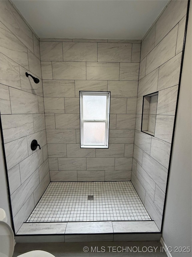 bathroom with toilet and a tile shower