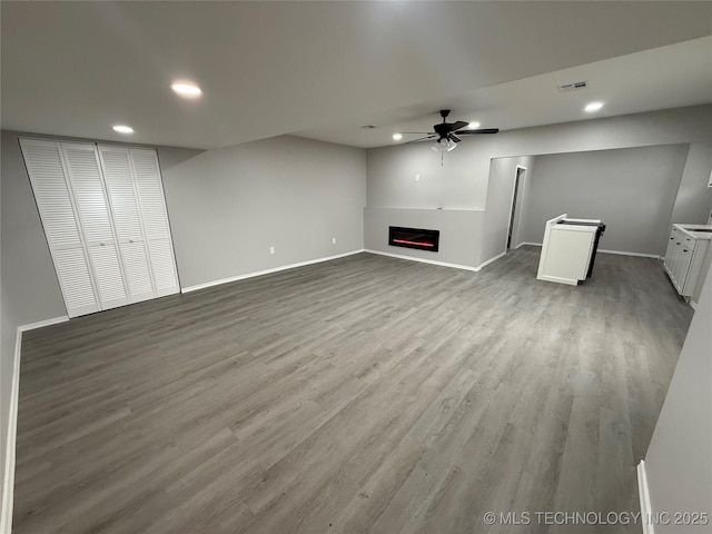 unfurnished living room featuring ceiling fan and light hardwood / wood-style floors