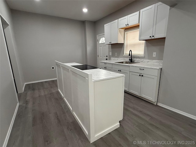 kitchen with a center island, white cabinetry, dark hardwood / wood-style flooring, sink, and black electric cooktop