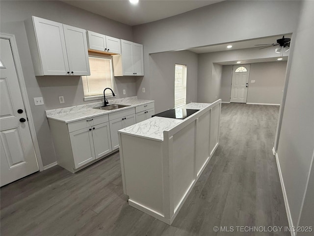 kitchen featuring ceiling fan, sink, white cabinets, and black electric stovetop