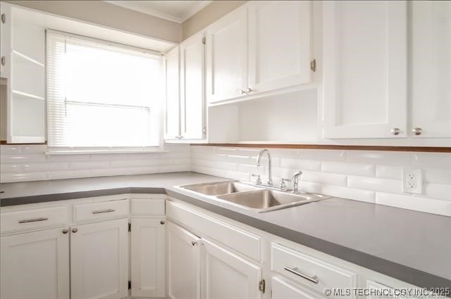 kitchen featuring sink, white cabinetry, and tasteful backsplash