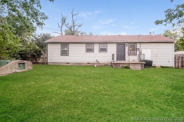 back of house featuring cooling unit and a lawn