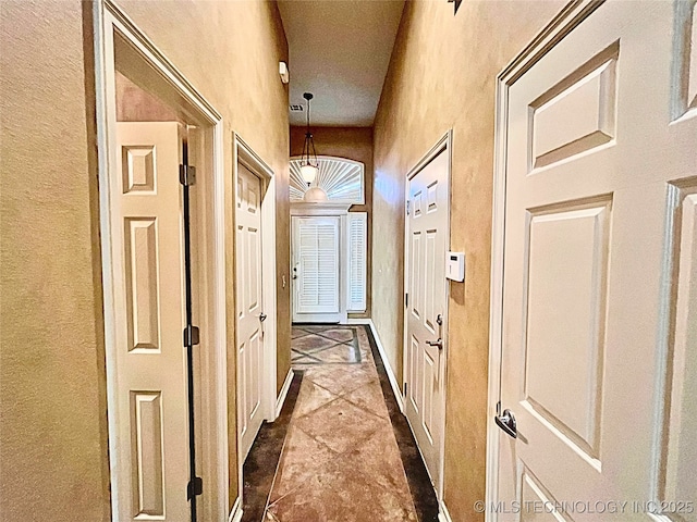 hallway featuring a towering ceiling