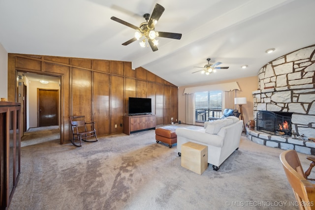 living room with a fireplace, wooden walls, light colored carpet, and vaulted ceiling with beams