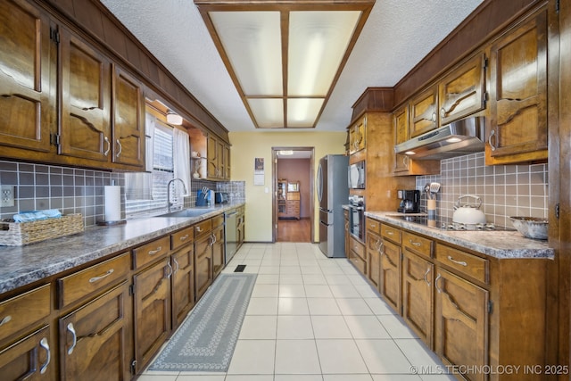 kitchen featuring tasteful backsplash, sink, light tile patterned floors, and stainless steel appliances