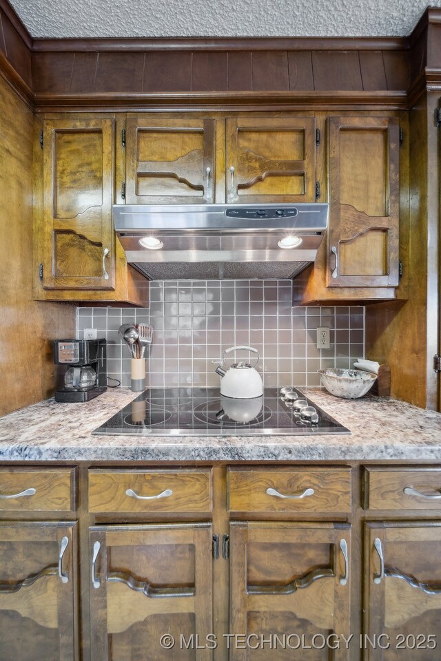 kitchen featuring black electric cooktop, decorative backsplash, and exhaust hood