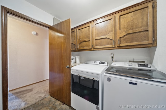 clothes washing area with cabinets and washer and clothes dryer