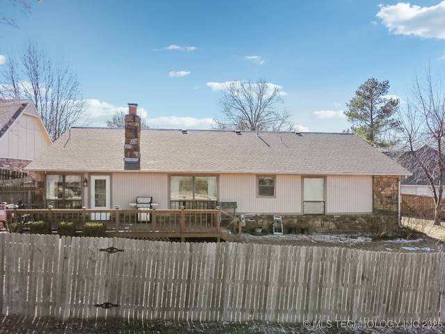 rear view of house featuring a wooden deck