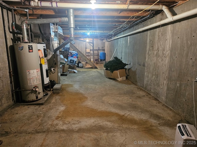 basement featuring gas water heater and electric water heater