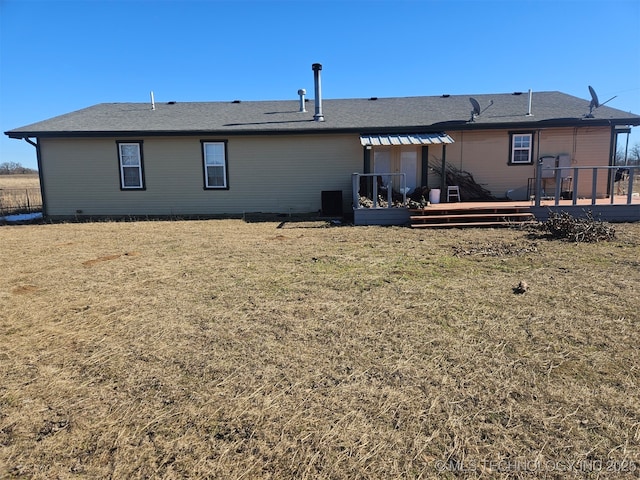 back of house featuring a wooden deck and a lawn