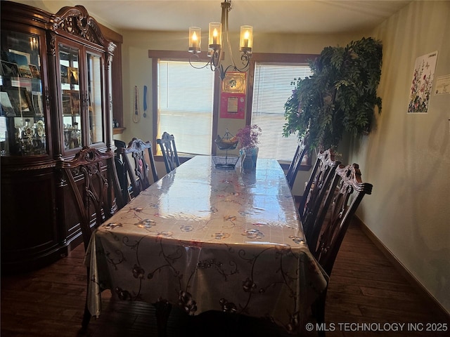 dining area featuring dark hardwood / wood-style floors and an inviting chandelier